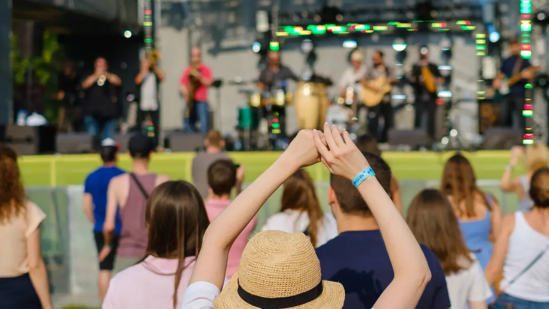 屋外のステージで演奏をしていて観客が周りで楽しんでいる